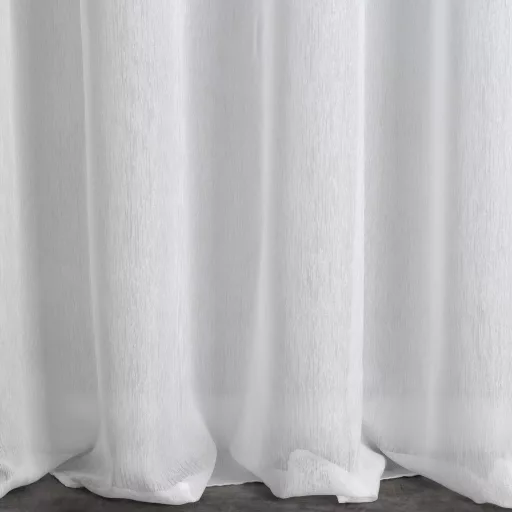 Prémium fehér voile készfüggöny esőszerű, függőleges textúrával és, finom fényű anyagból. Fém karikás kialakítása modern megjelenést biztosít, miközben kellemesen szűri a természetes fényt. 400X250 cm